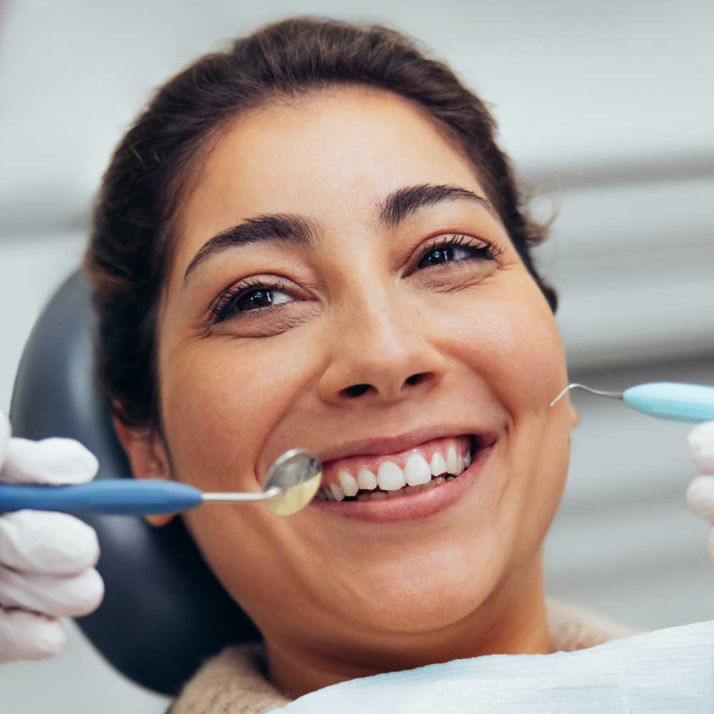woman smiling in dentist office exam chair