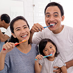 family brushing their teeth in bathroom
