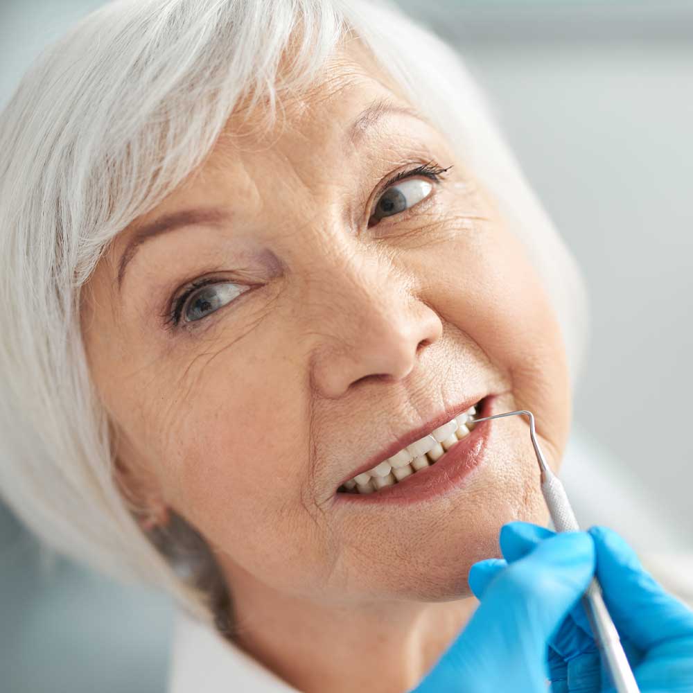 mature woman getting teeth checked in dental office