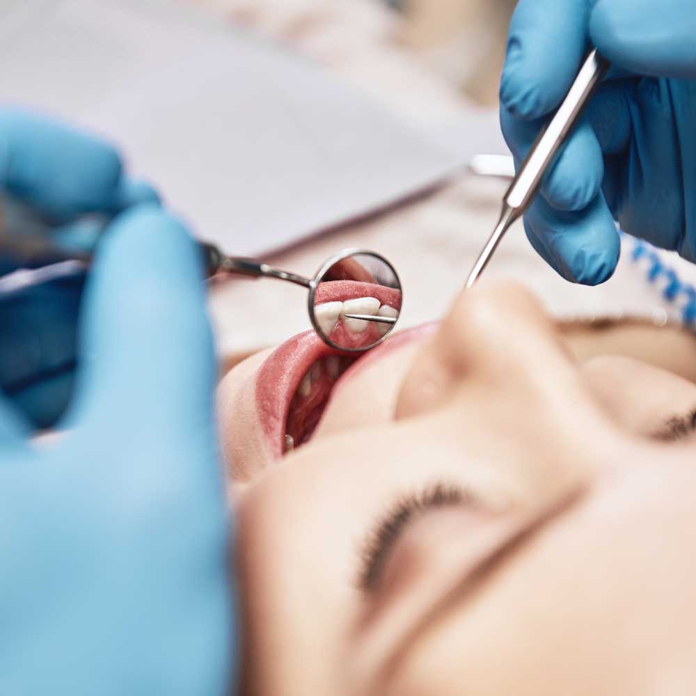dental hygienist checking tooth enamel